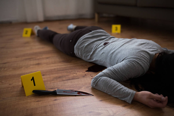 dead woman body lying on floor at crime scene - Foto, Imagem