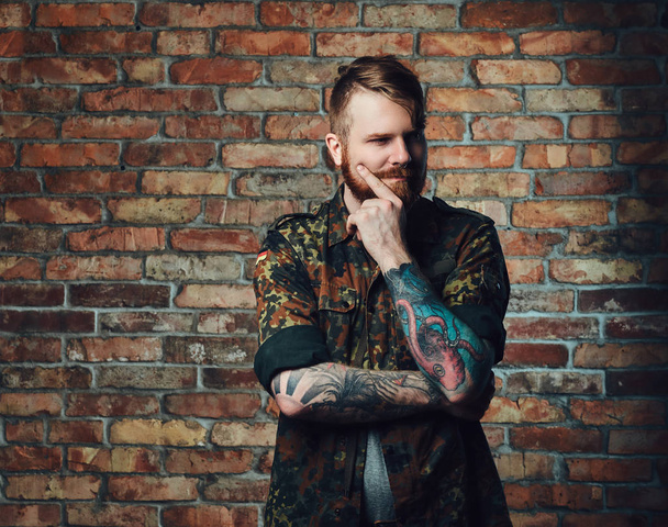 A tetoválás vörös hajú, szakállas férfi portréja - Fotó, kép