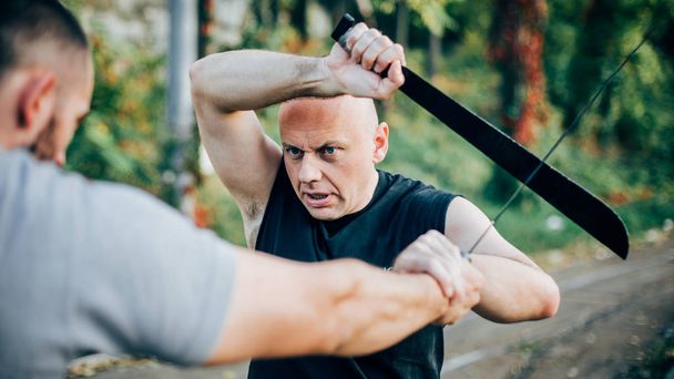 Martial arts instructor demonstrates machete fighting. Long knif - Foto, Imagen