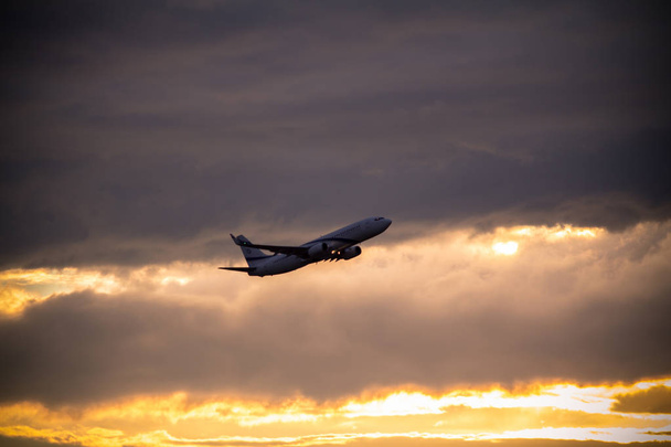 Silhouet van vliegtuig bij zonsondergang - Foto, afbeelding