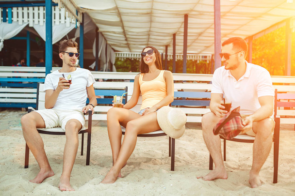 Young people enjoying summer vacation sunbathing drinking at beach bar - Zdjęcie, obraz