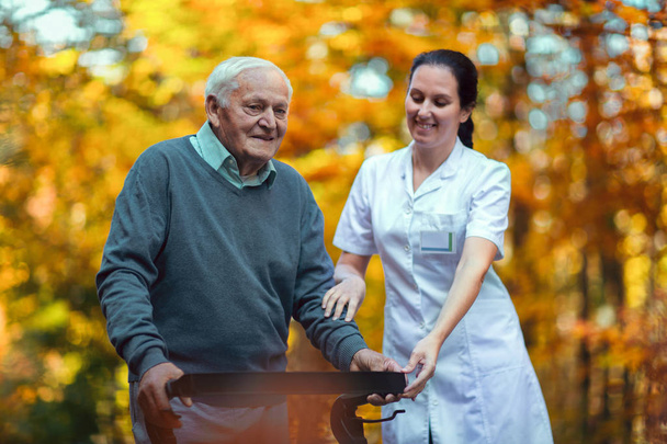 verpleegkundige helpen oudere man - Foto, afbeelding