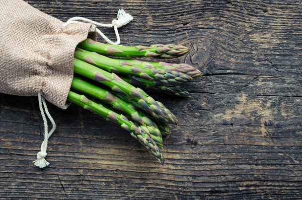 Bunch of asparagus in burlap bag - Фото, зображення