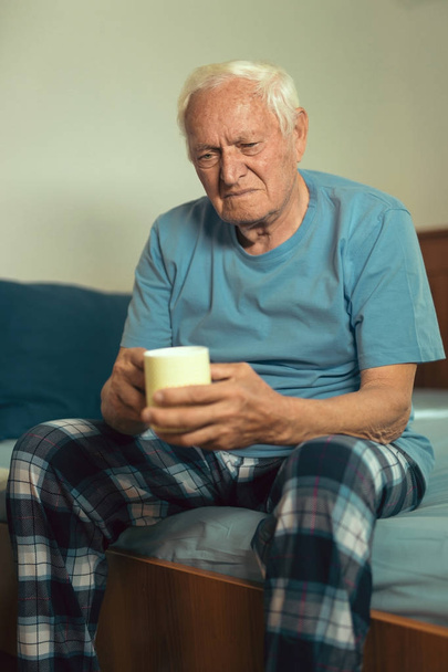 Старший мужчина сидит на кровати
 - Фото, изображение