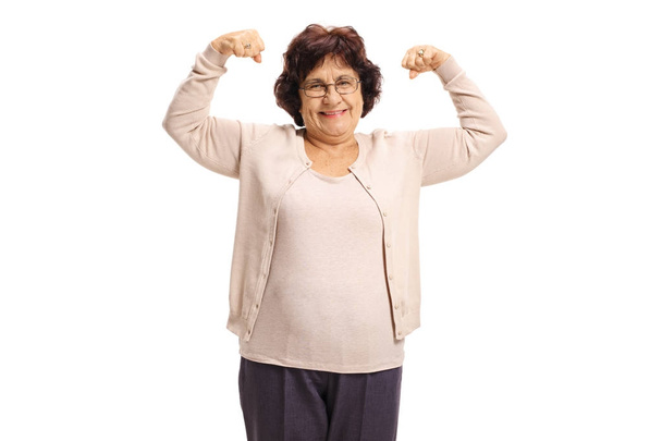 Elderly woman flexing her biceps - Fotoğraf, Görsel