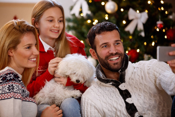 娘とクリスマス selfie を作る子犬の両親 - 写真・画像