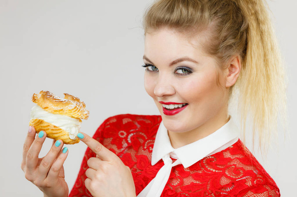 Happy woman holding choux puff cake - Foto, Imagen
