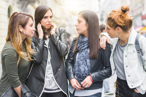 Portrait of four pretty girl friends, gossip on the street - Foto, afbeelding