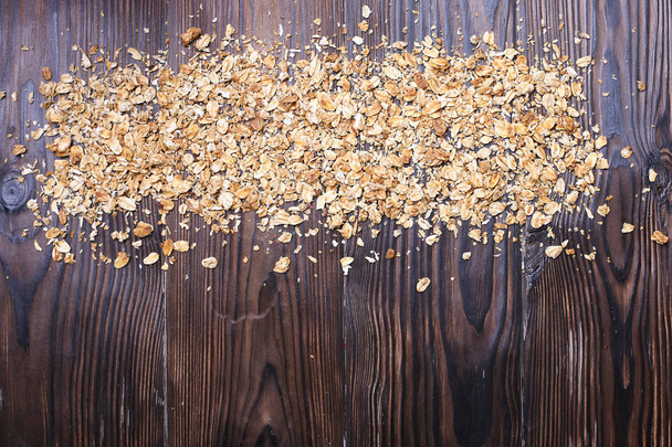 Granola superfood energy bars with almonds, hazelnut nuts, dry fruits, raisins, honey on the wooden board on the brown wood table, top view - Foto, immagini