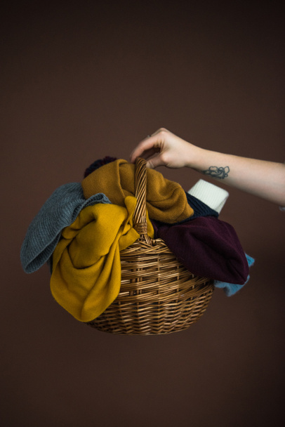 woman holding basket with hats and scarfs - Фото, изображение