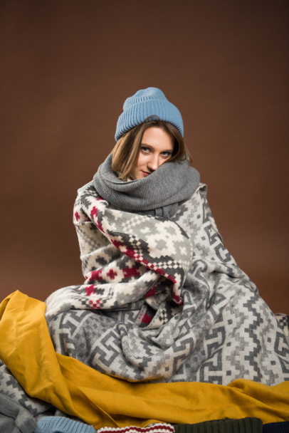 Femme assise enveloppée dans des couvertures
 - Photo, image