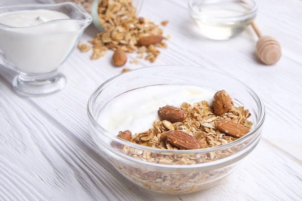 Homemade healthy granola or muesli with yogurt on white wooden background - Foto, immagini