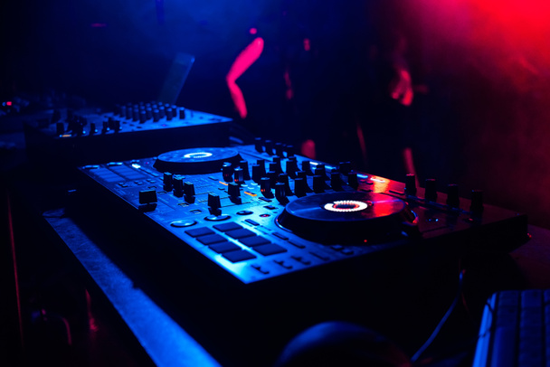 controlador de música mixer DJ controle de música sob a luz de holofotes em cabine na boate
 - Foto, Imagem