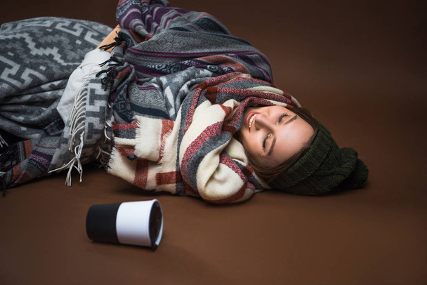 femme couchée sur le sol enveloppée dans des couvertures
  - Photo, image
