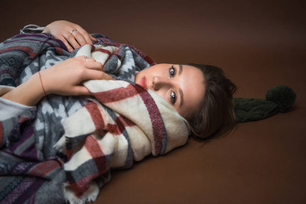 Yerde yatarken kız battaniyeye sarılmış  - Fotoğraf, Görsel