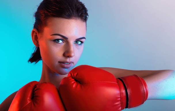 ボクシングのスポーツ手袋で黒い髪とセクシーなゴージャスな女性のファッション スタジオ写真。Bloxing 手袋色背景の上カメラ目線で若いフィットネス女の子 - 写真・画像