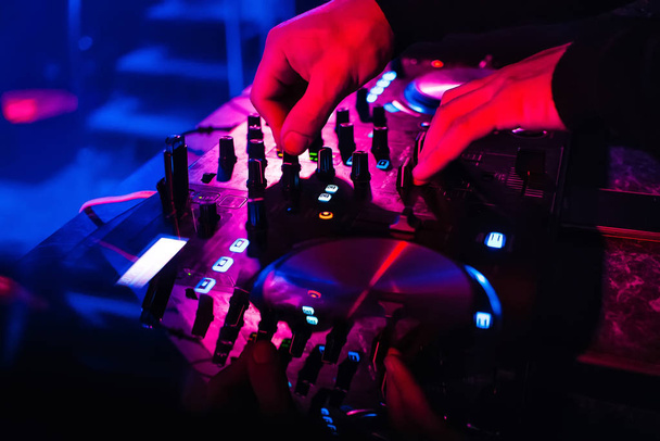 DJ mischt und steuert Musik auf professionellem Equipment - Foto, Bild