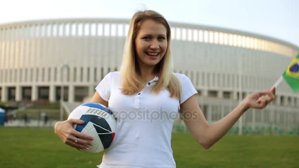 Donna con un pallone da calcio, la bandiera di Russia e Brasile. Tifoso di calcio sullo sfondo dello stadio
. - Filmati, video