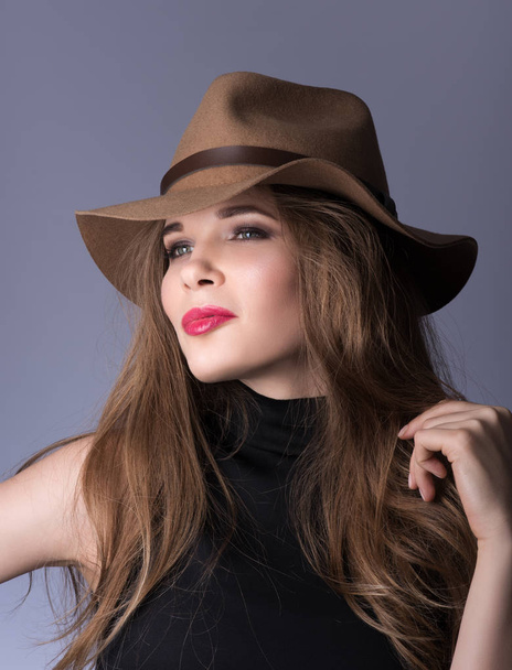 Retrato de belleza. Hermosa joven con un sombrero marrón y ropa negra
 - Foto, imagen