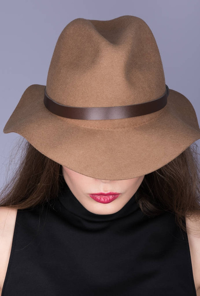 Vertical portrait of a woman in a brown hat and black clothing with her hair - Foto, Imagem
