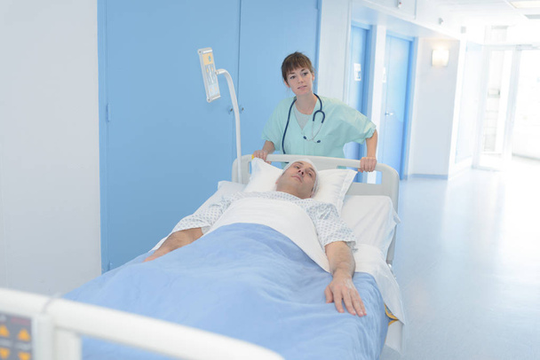 nurse transferring the patient to the recovery room - Foto, afbeelding