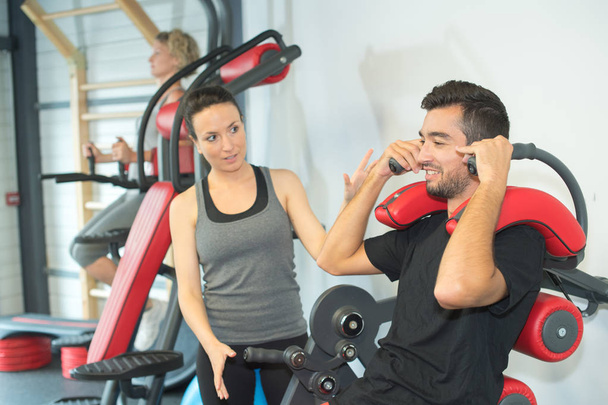 personal trainer instructing trainee in gym - Foto, Imagem