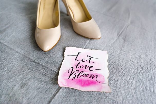 Wedding white shoes and romantic phrase - let love bloom. - Фото, изображение