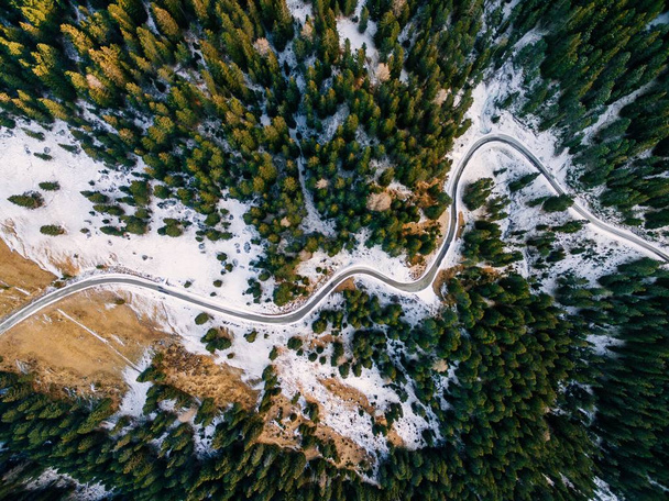 Yollu karlı ormanın havadan görünüşü. Yukarıdan bir İHA ile yakalandı.  - Fotoğraf, Görsel