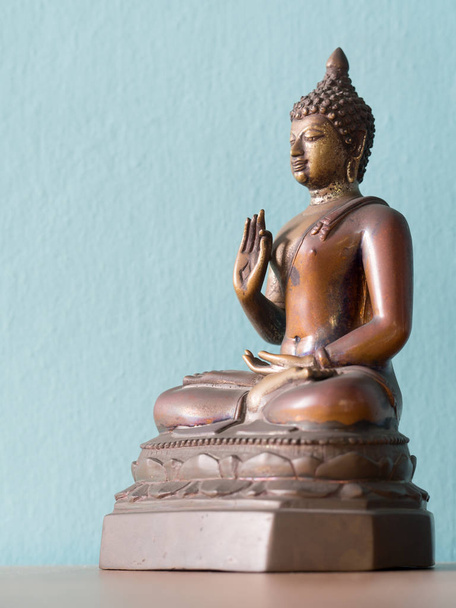 Statua Buddha antico su tavolo di legno. Lo sfondo è blu polvere (isolato
) - Foto, immagini