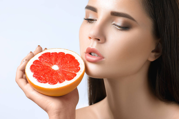 Pretty woman with delicious grapefruit in her arms. - Photo, image