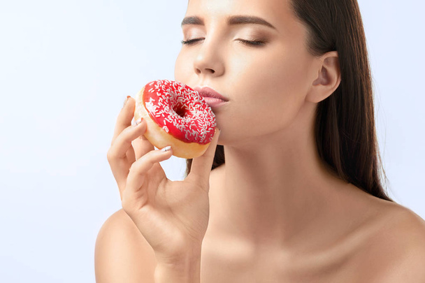 beautiful woman biting a donut - Foto, Imagen