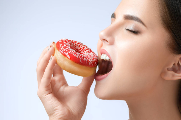 beautiful woman biting a donut - 写真・画像