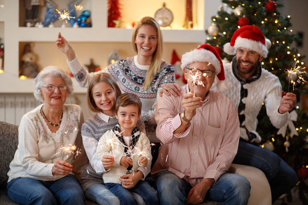 Happy family with sparkles at Christmas eve - Fotoğraf, Görsel