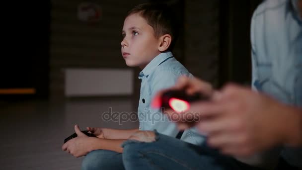Bir denetleyici bir oyun konsolu için ve içinde belgili tanımlık geçmiş çocuk holding eller musluk ve video oyunları oynarken inceliyor. Birinden diğerine odak kayar. - Video, Çekim