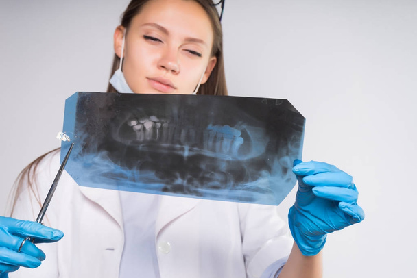 smart focused woman doctor examining an x-ray of teeth - Fotó, kép