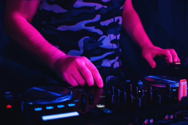 DJ spielt im Nachtclub am Mischpult und mit professionellem Equipment - Foto, Bild