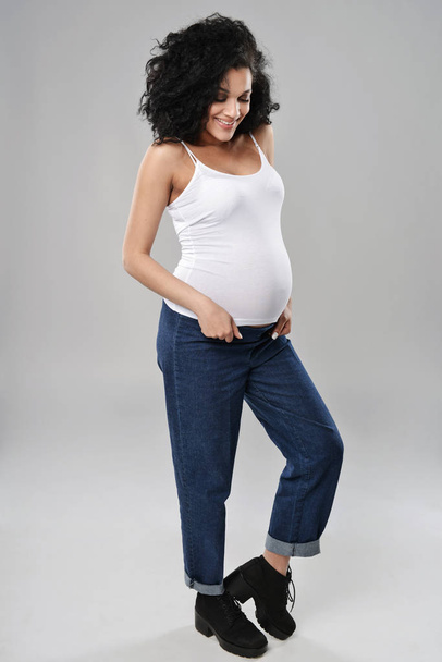 Pregnant woman standing in full length - Foto, afbeelding