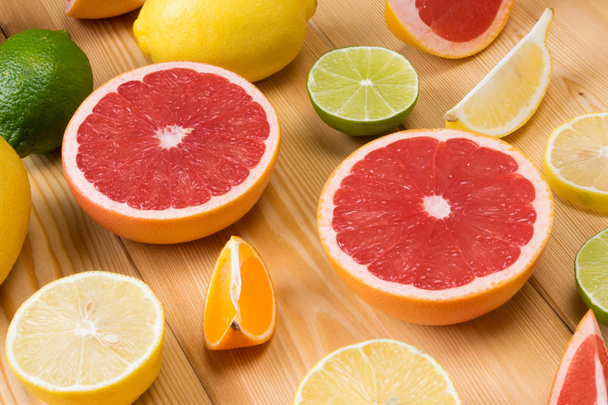 a set of sliced citrus fruits lie together on a wooden board - Фото, зображення