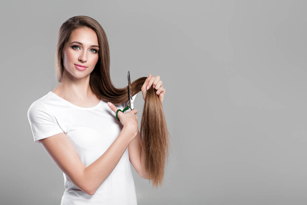 woman with  long hair holds scissors - Foto, Imagen
