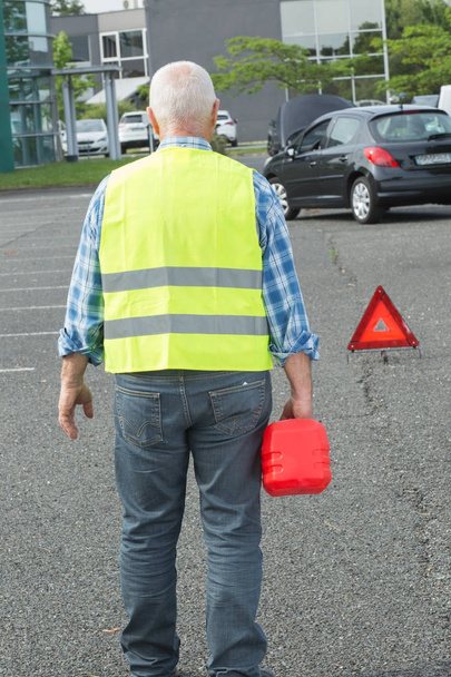 senior aged man holding gas can to refill his car - Photo, image