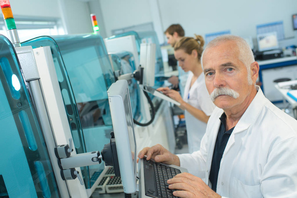 senior doctor looking at ct scanner in hospital laboratory - Fotó, kép