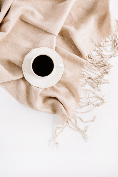 Filiżanka kawy na blady beżowy pastelowy plaid. Widok płaski świeckich, top - Zdjęcie, obraz
