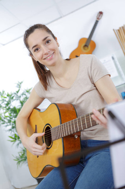 young lady playing acoustic guitar - Fotó, kép