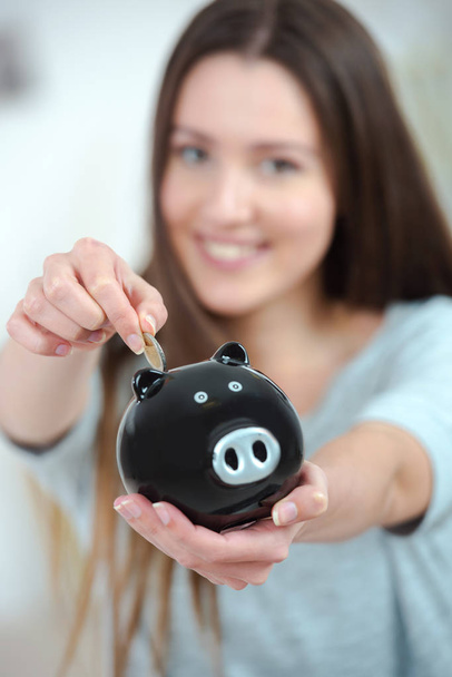 woman putting coin in piggy bank - Foto, Imagem