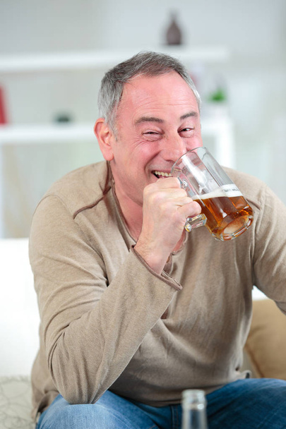 Jolly middle aged man drinking beer - Фото, зображення