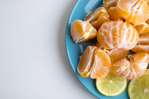 Blue plate with sliced lemon and tangerine - Photo, Image