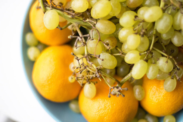 Piatto blu con uva da frutto con mandarino
 - Foto, immagini