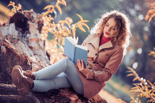 Portrait of beautiful woman reading book in nature. - Valokuva, kuva