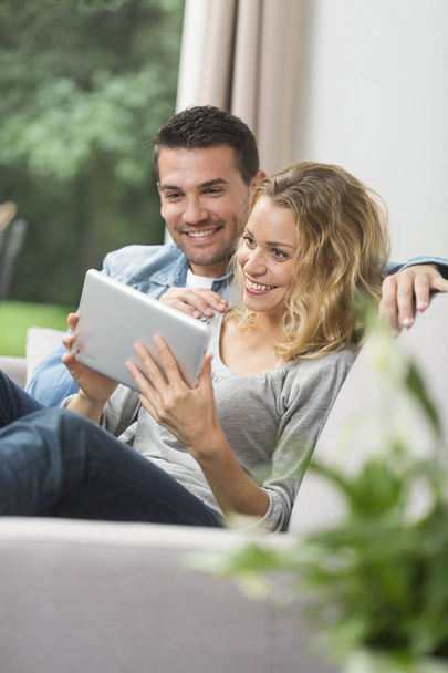 ευτυχές νεαρό ζευγάρι βλέποντας internet στο tablet τους - Φωτογραφία, εικόνα