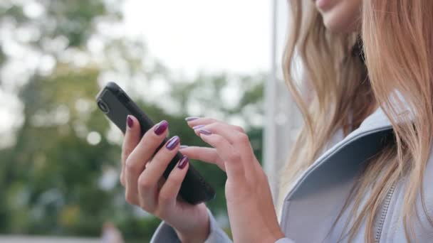 Una joven usando un teléfono inteligente al aire libre
 - Metraje, vídeo